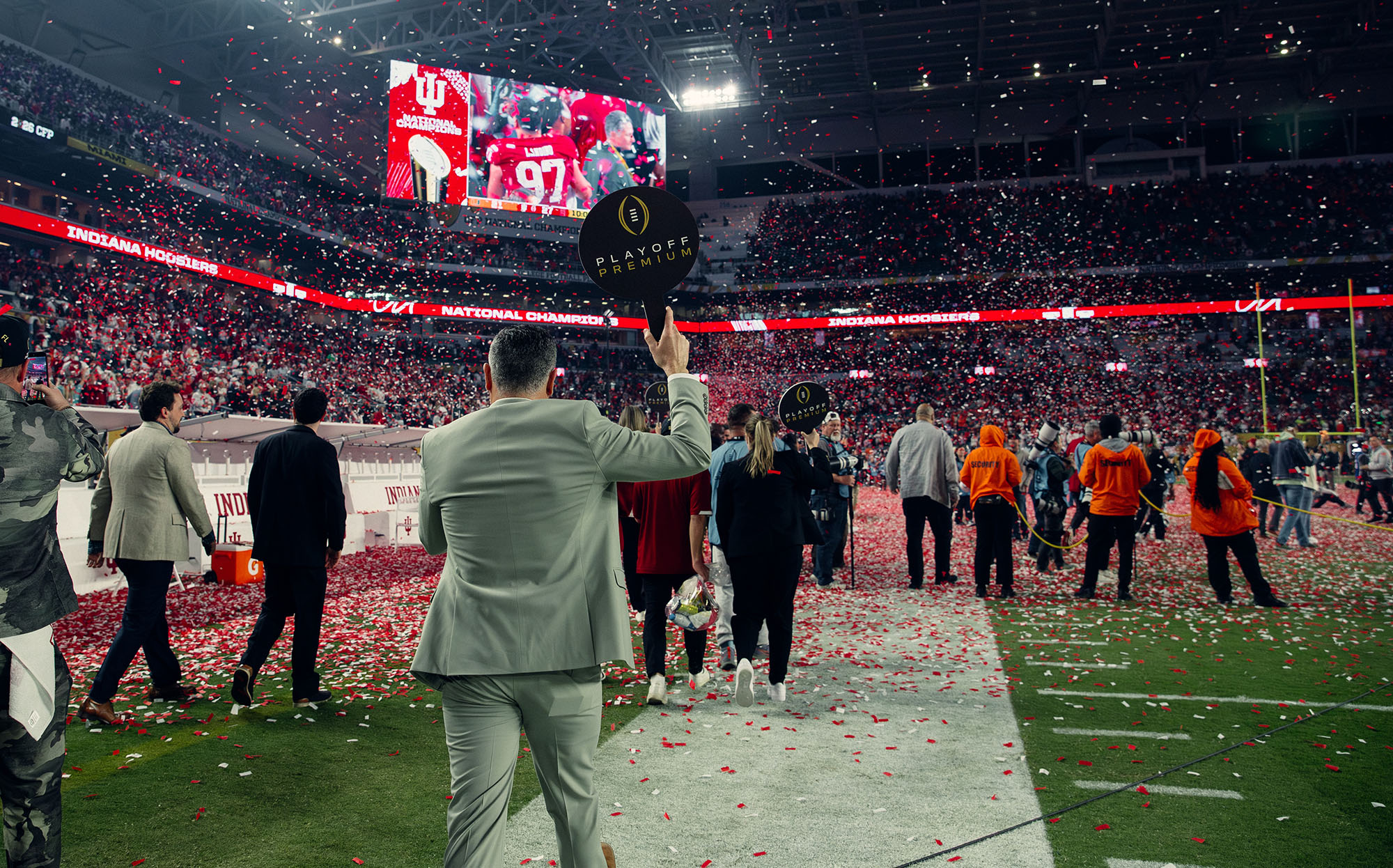 A Playoff Premium host on the field as confetti falls at the end of the National Championship