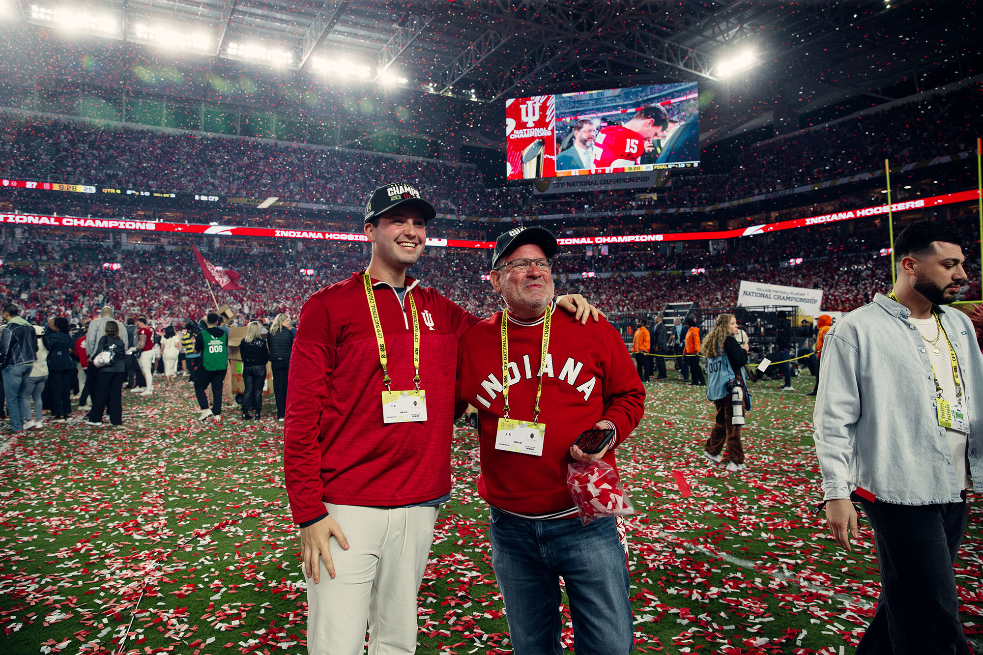 Two guests with field passes on the confetti-covered field after the National Championship